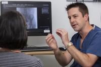 Physician explains procedure to female patient.